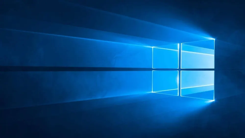 Blauer Hintergrund mit einem leuchtenden, quadratischen Windows-Logo, das in vier kleinere Quadrate unterteilt ist. Helle Lichtstrahlen erhellen den Hintergrund.