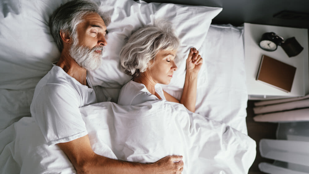 Ein Mann und eine Frau schlafen gemeinsam in einem Bett.