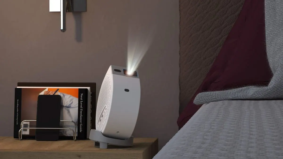 Der Mini-Beamer BenQ GV50 steht neben einem Bett auf einem Nachttisch und projiziert schräg nach oben.