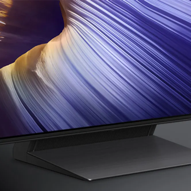 Unterer Bereich eines Fernsehbildschirms mit violetten und gelben Farbtönen, moderner Standfuß in dunkler Farbe.