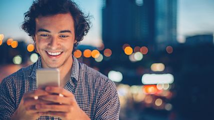 Mann mit Smartphone bei Dunkelheit