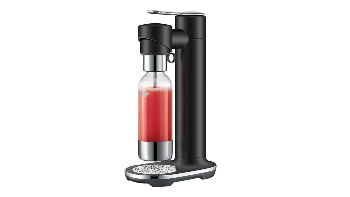 Der Wassersprudler Sage InFizz Fusion vor weißem Hintergrund, im Sprudler hängt eine Flasche mit einer roten Flüssigkeit.