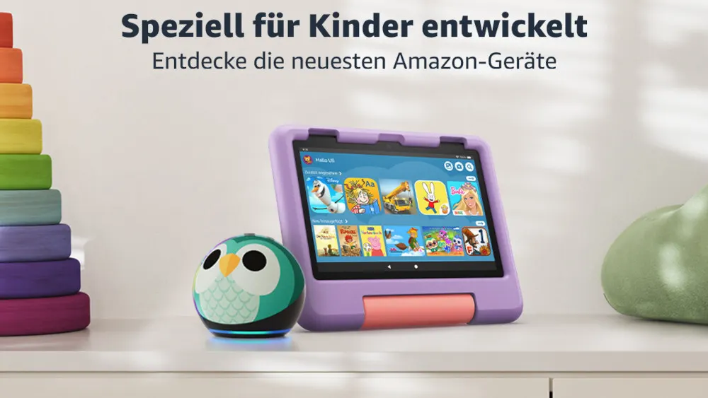 Ein Tablet mit lila Hülle, ein grüner Lautsprecher in Eulenform und ein Turm aus bunten Holzscheiben stehen auf einem Tisch.