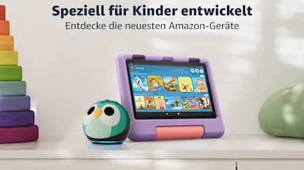 Ein Tablet mit lila Hülle, ein grüner Lautsprecher in Eulenform und ein Turm aus bunten Holzscheiben stehen auf einem Tisch.