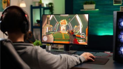 Ein junger Mann sitzt vor einem Gaming PC.