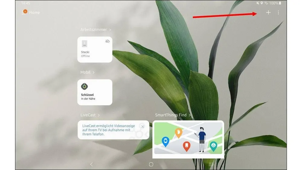 Tablet-Bildschirm mit App-Symbolen und einer grünen Pflanze im Hintergrund. Pfeil zeigt auf das Pluszeichen in der oberen Ecke.