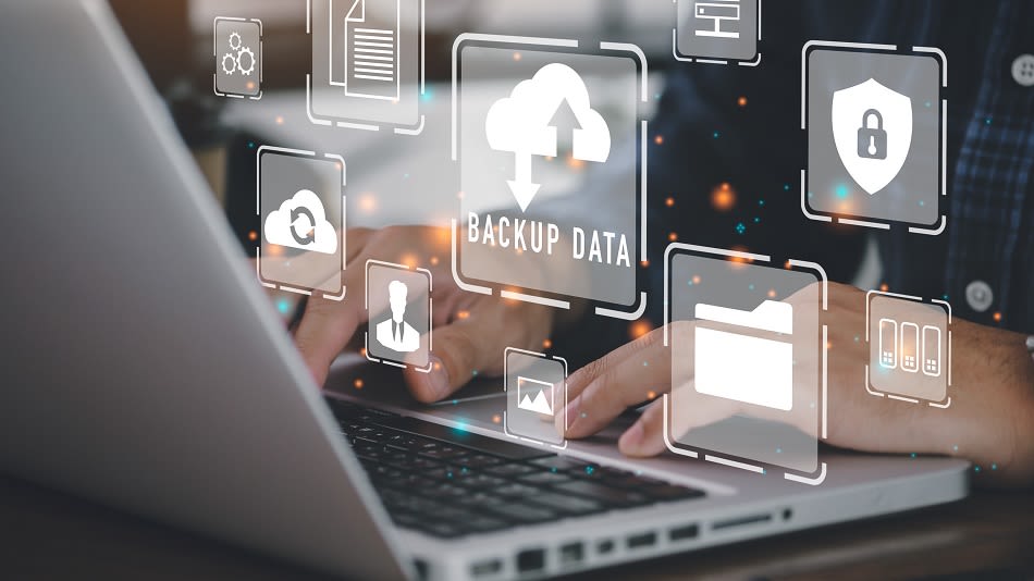 Person vor Laptop mit verschiedenen Symbolen zur Datensicherung bei vollem internen Speicher