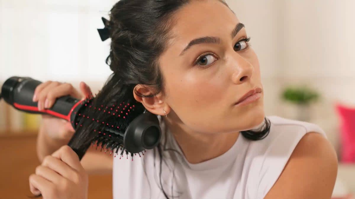 Eine Frau bürstet sich die Haare mit dem Revlon RVDR5298E One-Step Volumiser Plus.