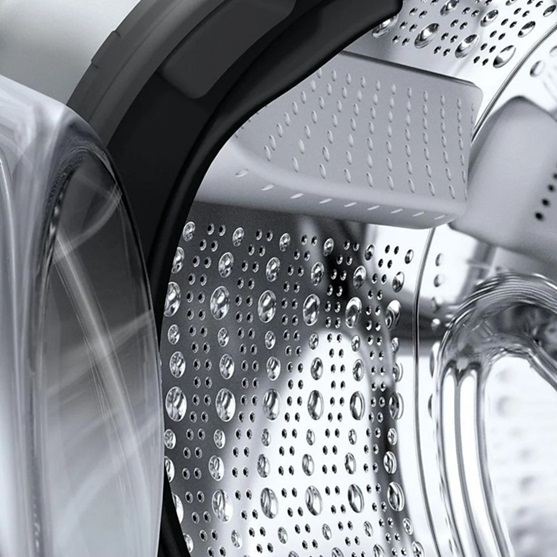 Detail der Edelstahltrommel der SIEMENS WM14NKECO5 iQ300 Waschmaschine, Türdichtung und Mitnehmer sichtbar, Wasserperlen auf der Oberfläche betonen schonende Wäschepflege.