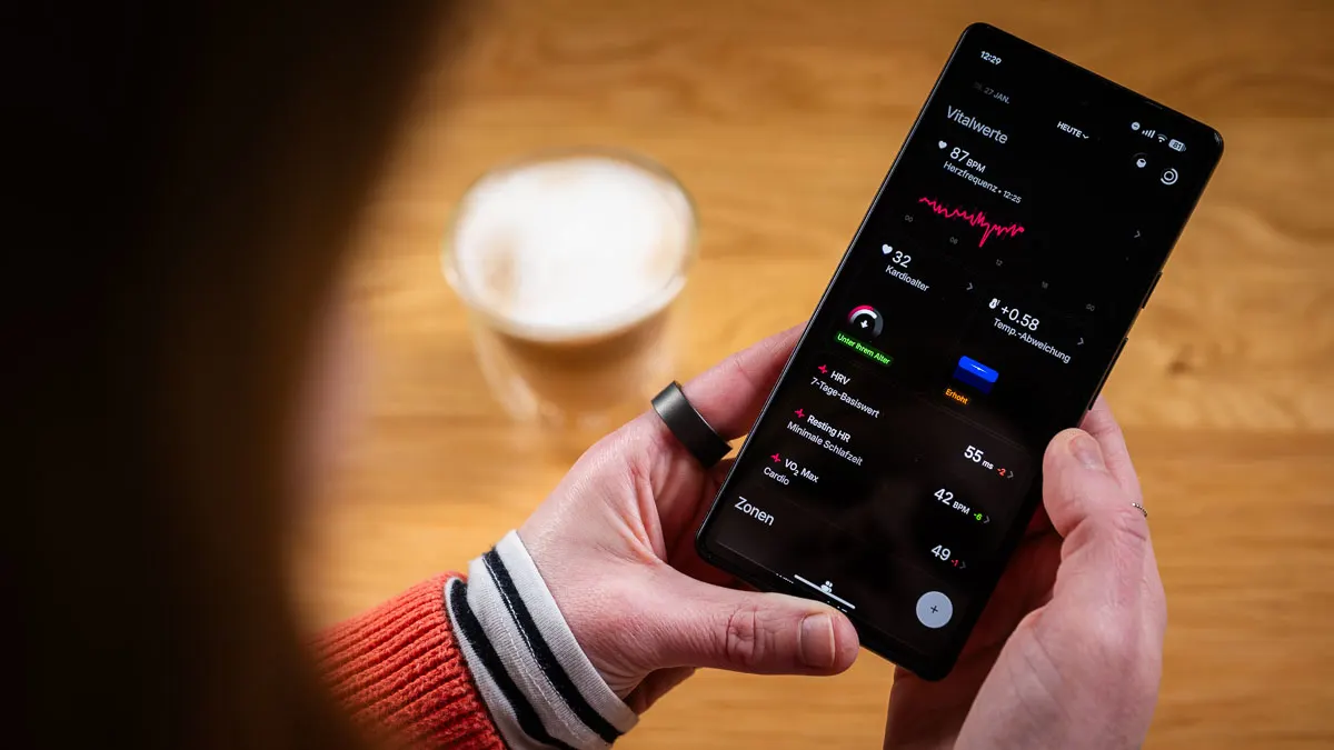 Franzi trägt den Ultrahuman Ring Air am linken Zeigefinger und schaut sich Vitalwerte in der Ultrahuman-App an.