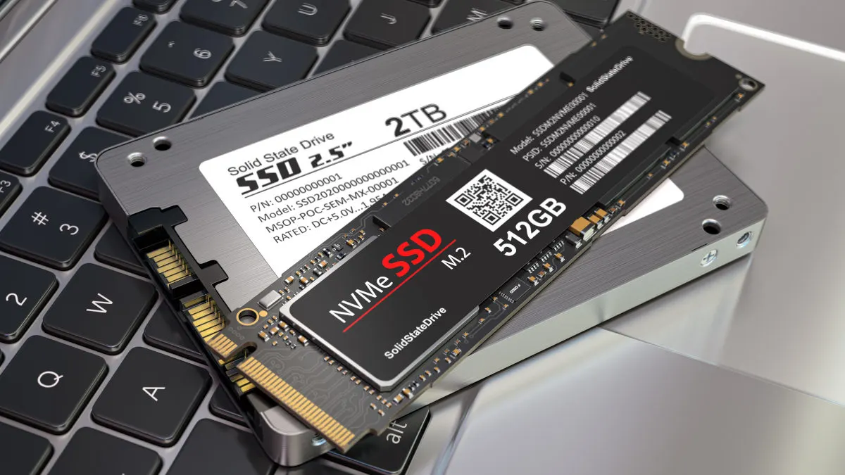 Auf einer Laptop-Tastatur liegen zwei SSD-Laufwerke: ein 2-TB- und ein 512-GB-Solid-State-Drive.