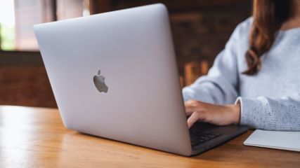 Eine Frau arbeitet an einem Macbook