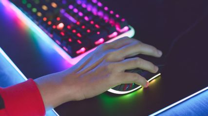 Ein junger Mensch nutzt eine Gaming-Maus, daneben eine Gaming-Tastatur.