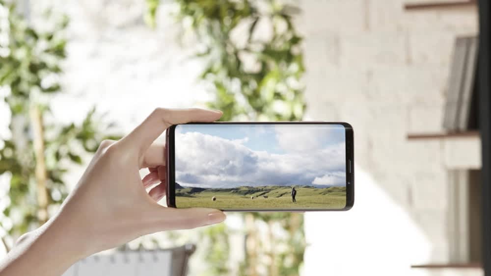 Eine Person hält ein Galaxy S9 Plus in der Hand und schaut auf dem Smartphone ein Video.
