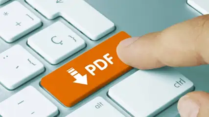 Nahaufnahme einer Hand, die eine orangefarbene Taste mit der Aufschrift „PDF“ und einem Download-Symbol auf einer weißen Tastatur drückt.
