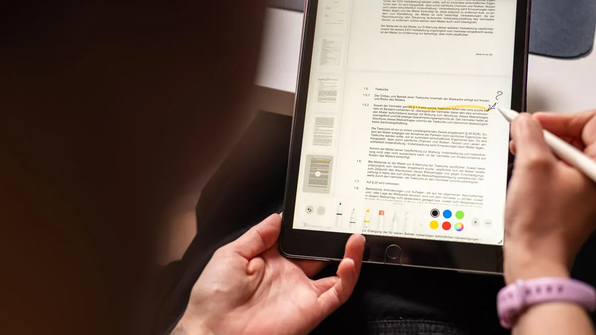 Ein iPad mit Markierungen, darüber hält eine Hand einen Apple Pencil.