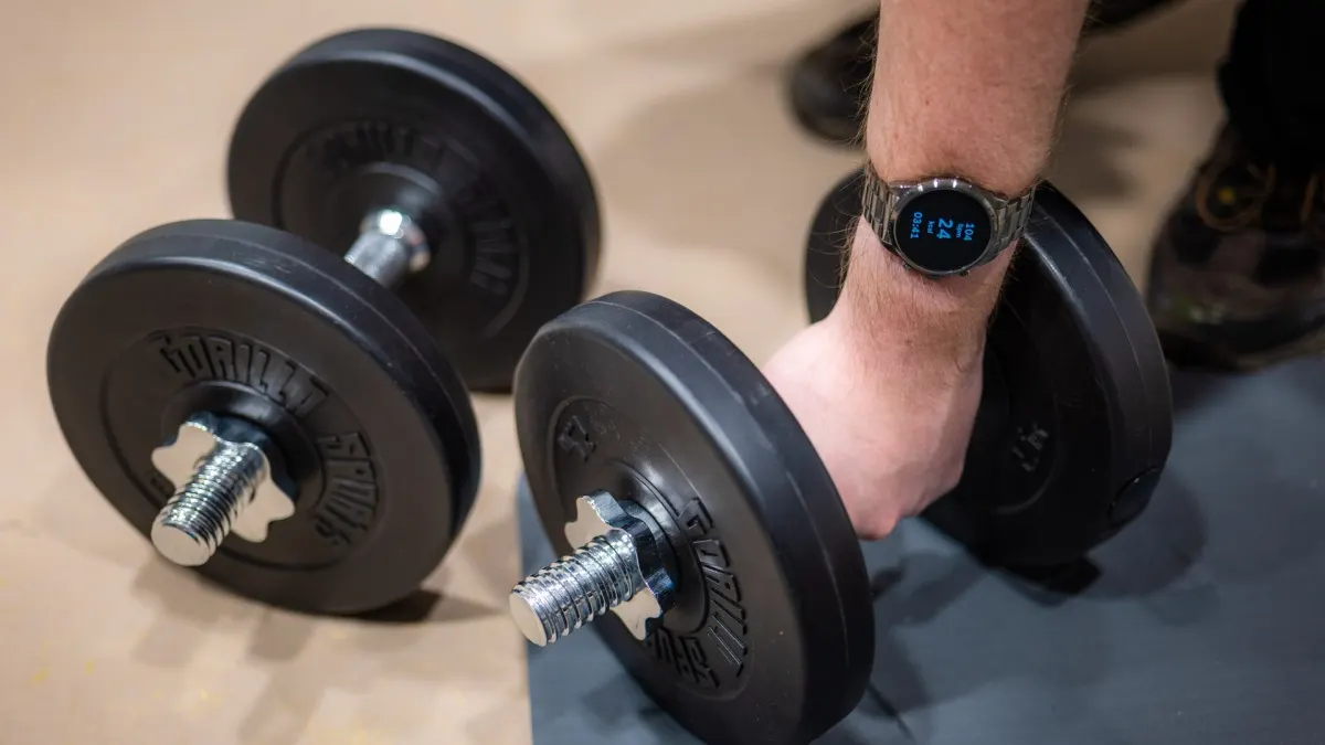 Andreas umfasst eine Hantel, während er am Arm die Fossil Gen 6 Watch trägt.