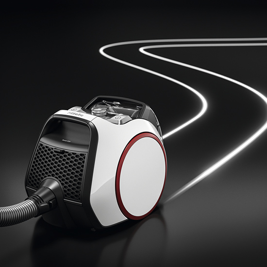 Ein weißer Staubsauger mit rotem Akzent steht auf einem schwarzen Untergrund mit Lichtstreifen im Hintergrund.