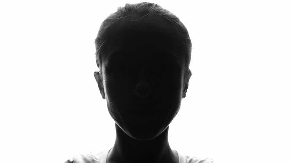 Die Silhouette einer Person steht vor einem weißen Hintergrund.