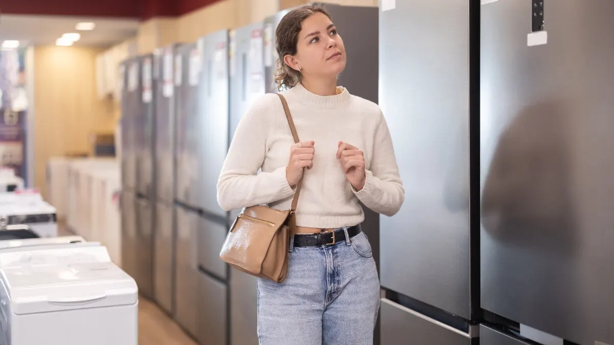 Eine Frau sieht sich Kühlschränke im Fachhandel an.