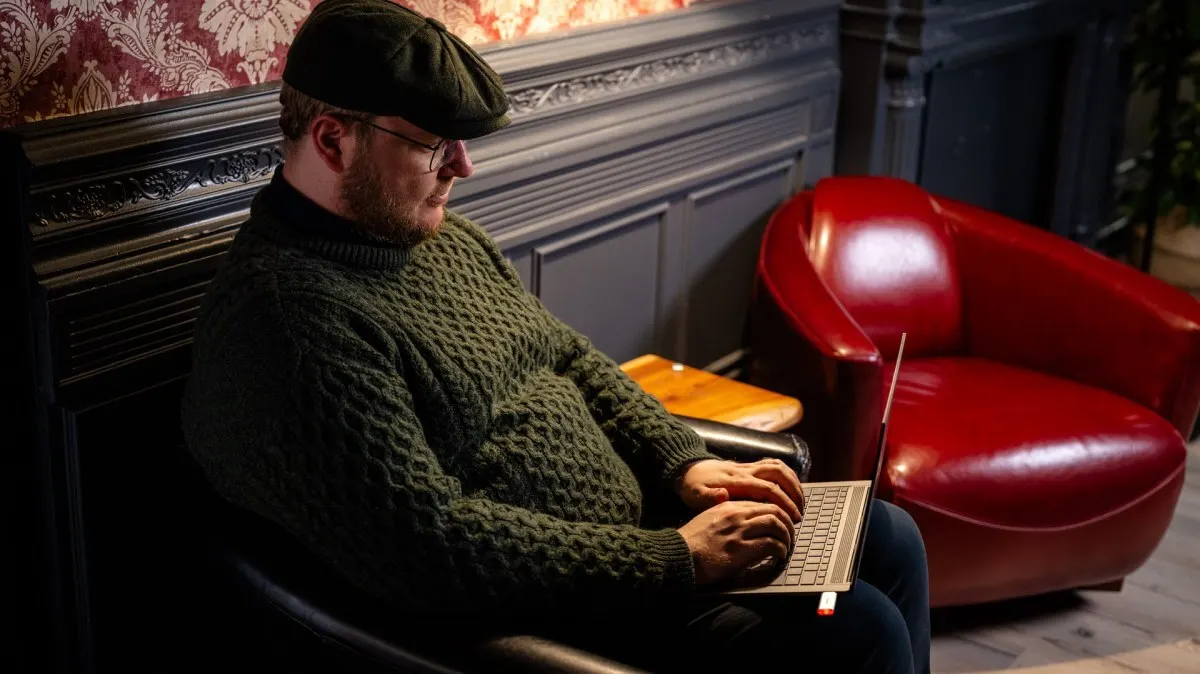 Andreas tippt auf einem Windows-Laptop.