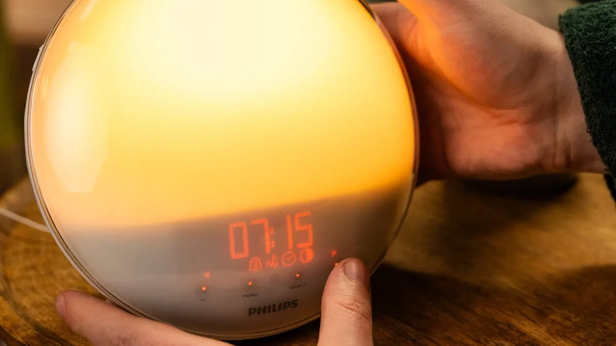 Eine Person bedient einen Philips-Lichtwecker per Touchsteuerung.