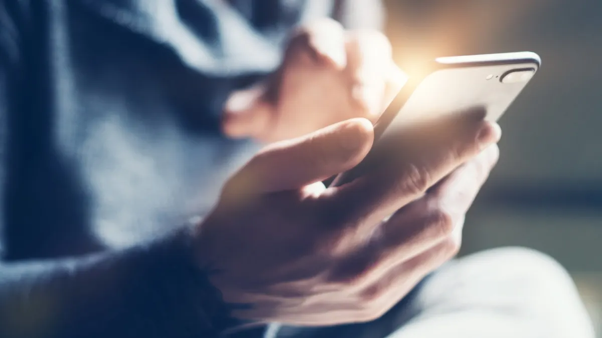 Eine Person tippt auf einem Smartphone.