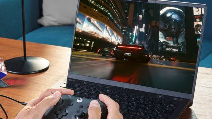 Person spielt Cyberpunk2077 mit Xbox-Controller auf einem AMD-Laptop