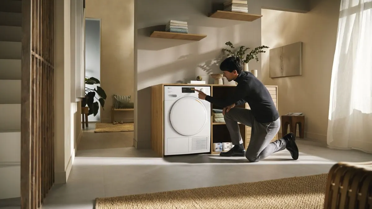 Ein Mann bedient den Wärmepumpentrockner Miele TWC660WP (125 Edition).