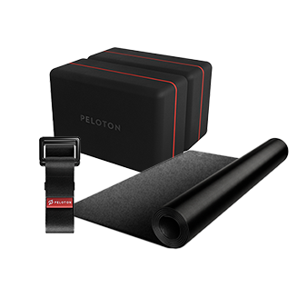 Eine schwarze Yoga Matte, ein Band und ein Yoga Block