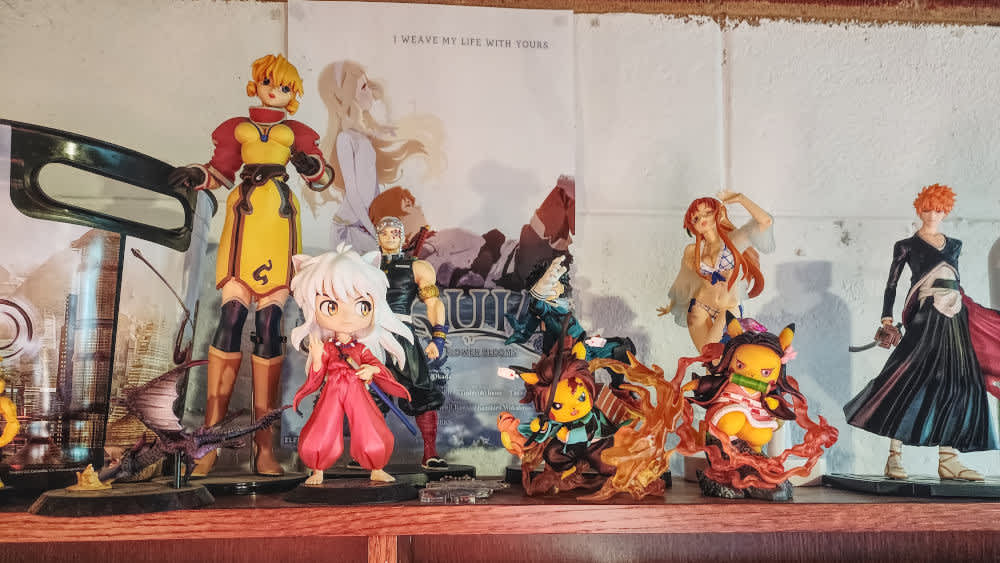 Verschiedene Anime-Figuren stehen auf einem Regal.