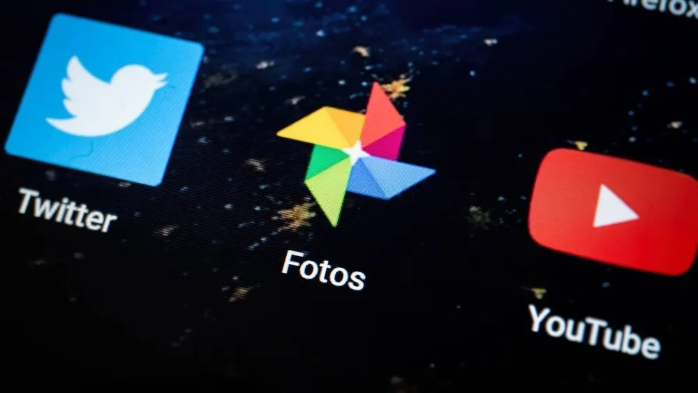 Auf einem schwarzen Bildschirm sind die Symbole für Twitter, Fotos und YouTube zu sehen.