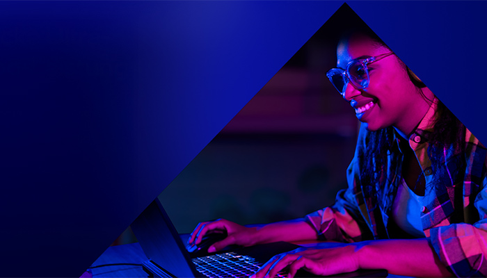 Eine Frau sitzt an ihrem Laptop und spielt ein Spiel.