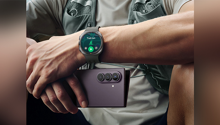 Person mit Smartwatch am Handgelenk hält ein Samsung Galaxy Z Fold8 Ultra in geschlossener Form mit Triple-Kamera in der Hand.