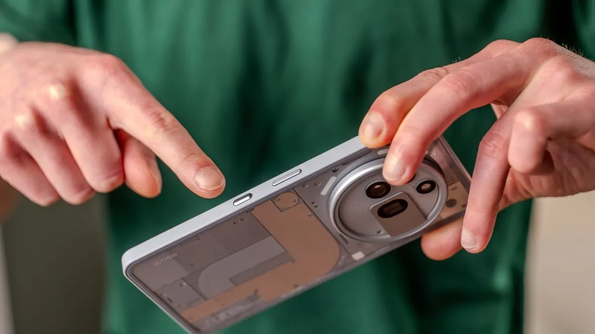 Alex zeigt mit dem Finger auf den Essential Key des Nothing Phone (3a) Pro.
