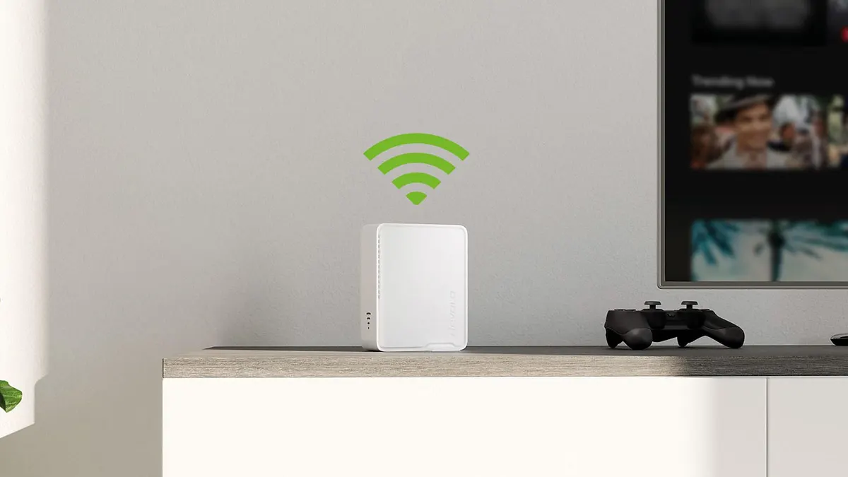 Der WLAN-Repeater Devolo Wi-Fi 6 Repeater 5400 steht auf einer hellen Anrichte neben einem Fernseher, darüber ist ein WLAN-Symbol zu sehen.