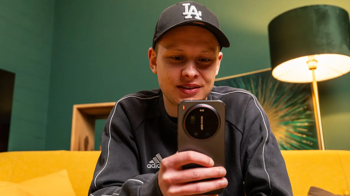 Alex sitzt auf einem Sofa und tippt auf dem Xiaomi 17 Ultra.