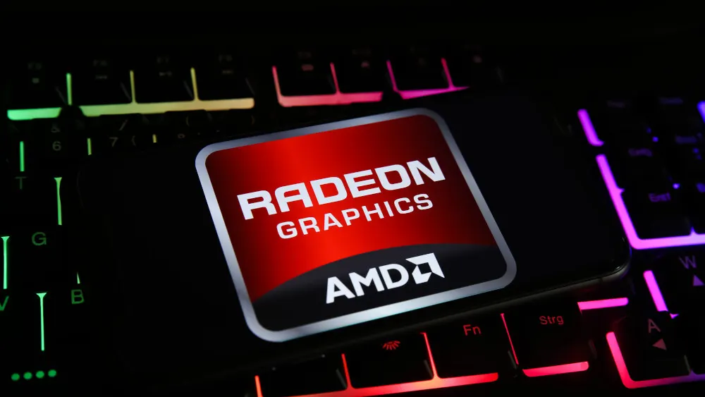 Auf einer beleuchteten Tastatur liegt ein Smartphone mit dem Radeon Graphics AMD-Logo auf rotem Grund. Die Tastatur leuchtet in Grün, Rot und Lila.