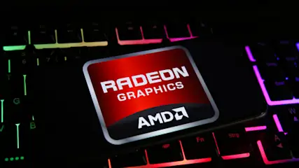 Auf einer beleuchteten Tastatur liegt ein Smartphone mit dem Radeon Graphics AMD-Logo auf rotem Grund. Die Tastatur leuchtet in Grün, Rot und Lila.