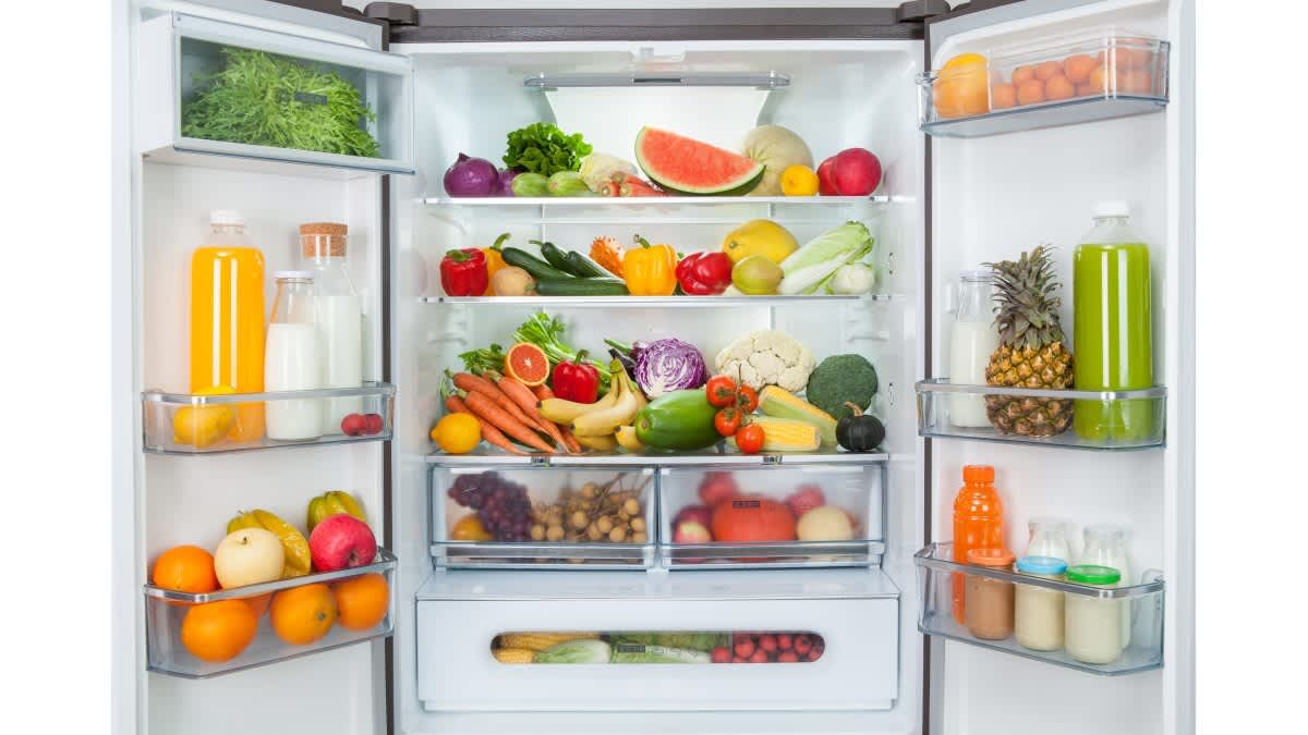 Ein Kühlschrank steht offen und ist mit Obst und Gemüse befüllt.