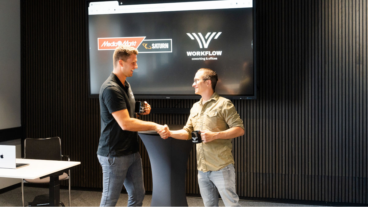 Franz Flemming, geschäftsführender Gesellschafter bei Workflow und MediaMarktSaturn Geschäftskundenberater Sascha Kretzschmar vor dem interaktiven Display der neuen Konferenz- und Event-Fläche.