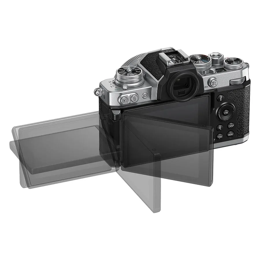 NIKON Z fc Kit Systemkamera mit Objektiv 16-50 mm, 7,5 cm Display Touchscreen, WLAN Eine silberne und schwarze Kamera mit einem schwenkbaren Bildschirm, der teilweise ausgeklappt ist, vor einem weißen Hintergrund.