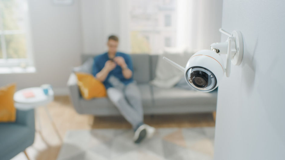 Eine Überwachungskamera hängt an der Wand eines Wohnzimmers.