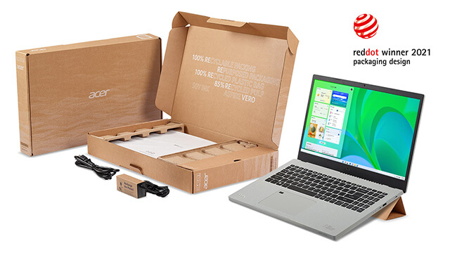 Ein Laptop neben geöffnetem Karton mit Zubehör und geschlossenem Acer Karton, ausgezeichnet mit Red Dot Winner 2021.