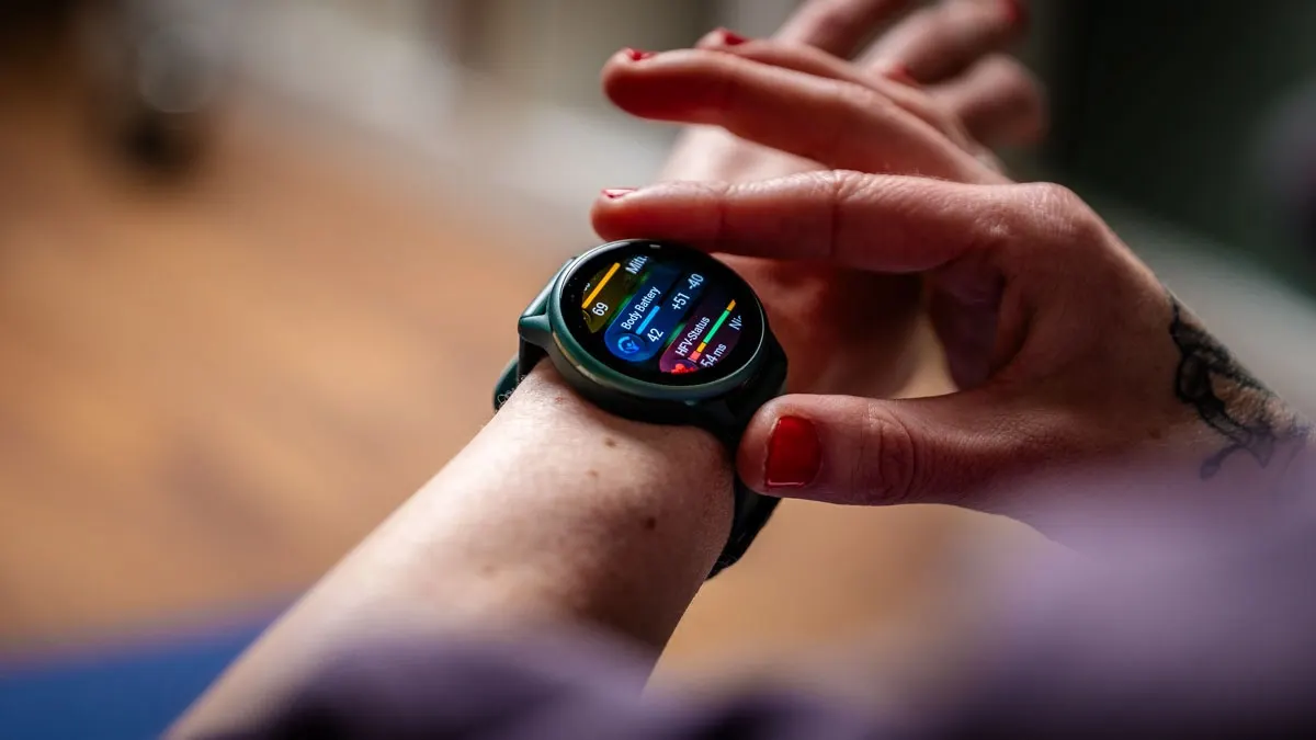 Eine Person trägt eine grüne Smartwatch am Handgelenk und tippt mit dem Finger auf das Display.