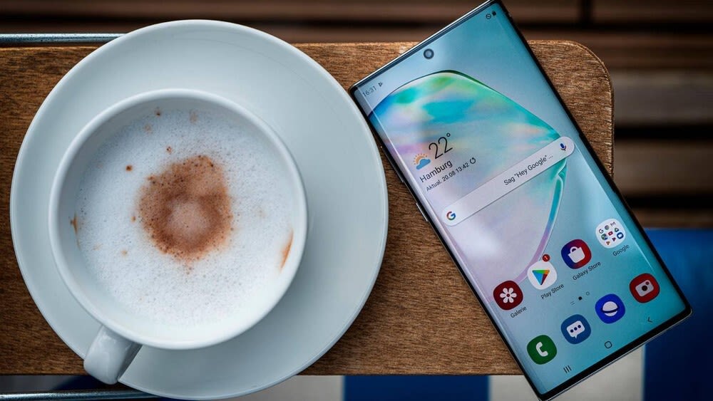 Smartphone liegt neben einem Kaffee