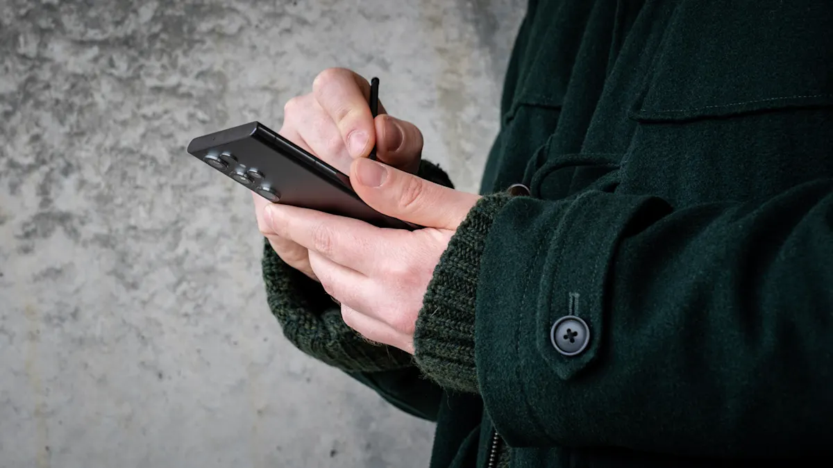 Andreas hält das Galaxy S22 Ultra in einer Hand und schreibt mit dem S Pen darauf.
