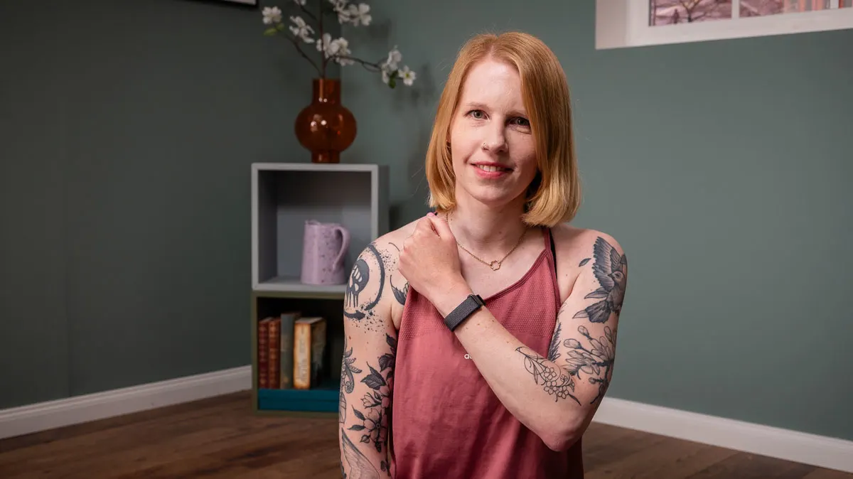 Franzi hält ihren linken Arm vor den Körper und trägt das Fitbit Air am Handgelenk.