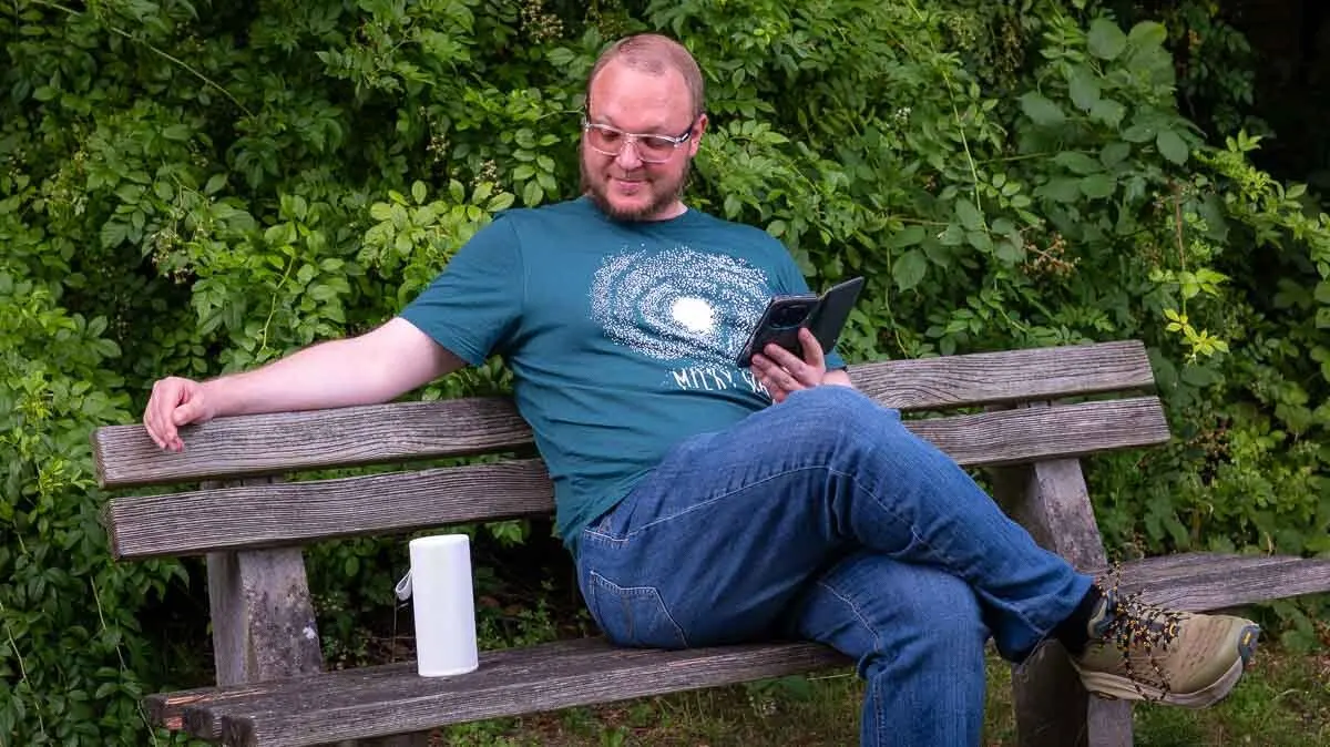 Andreas sitzt auf einer Parkbank, neben ihm steht ein Sonos Play.