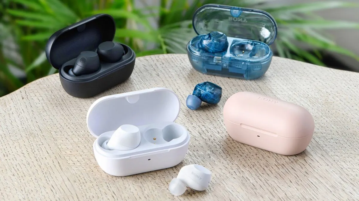 Drei Paar In-Ear-Kopfhörer Sony WF-C710N in verschiedenen Farben liegen samt Ladecases auf einem Tisch.